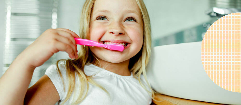 kid brushing teeth in bathroom