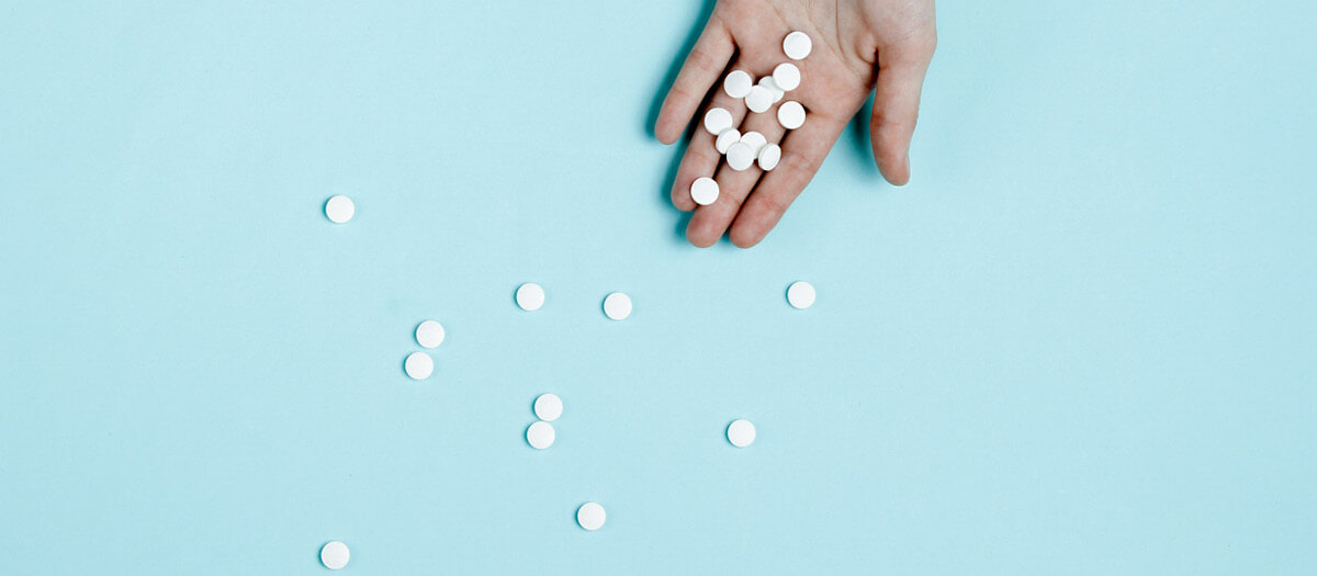 handful of blood thinners on blue background