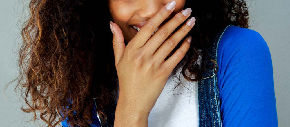 Woman hiding cold sore with her hand