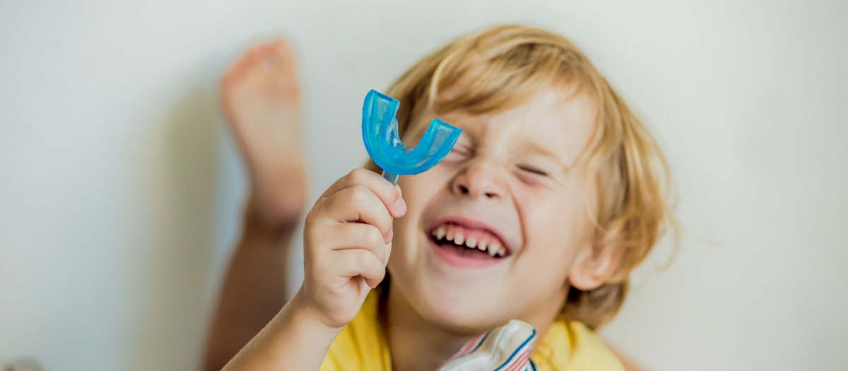 Kid with retainer on bed