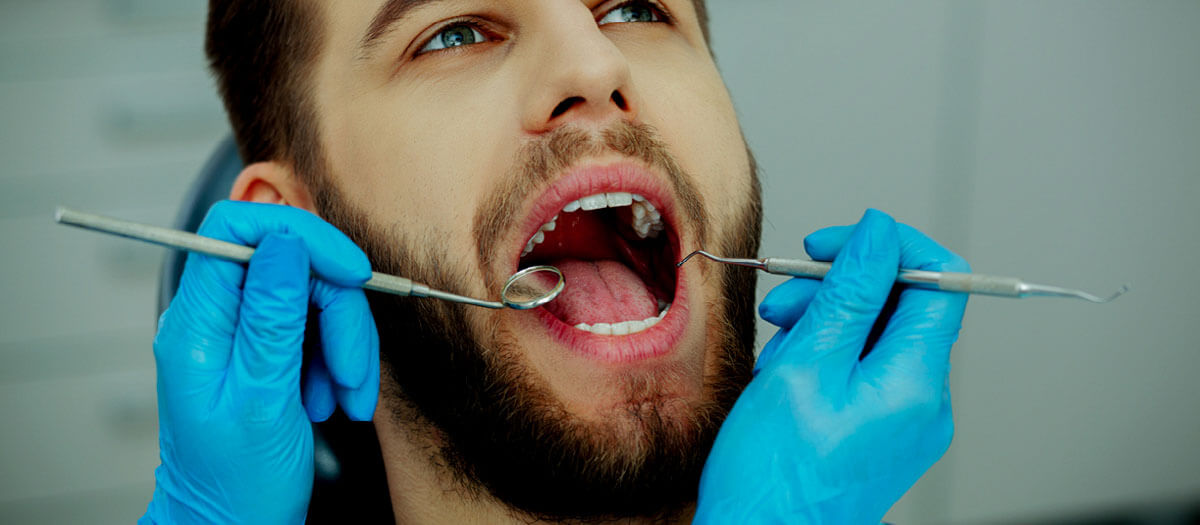 man getting dental cleaning on his teeth