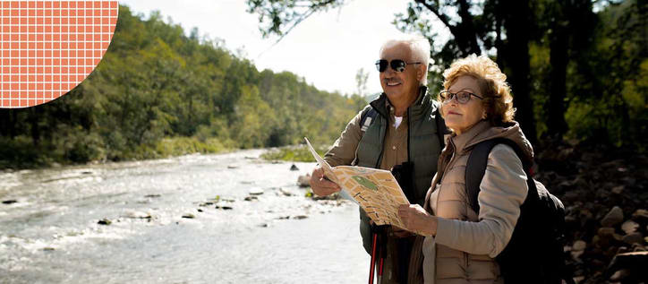 Senior couple looking at map near river