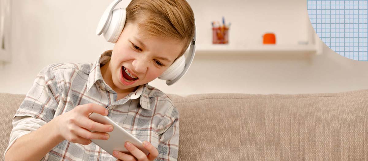 Boy with braces plating a video game on this phone