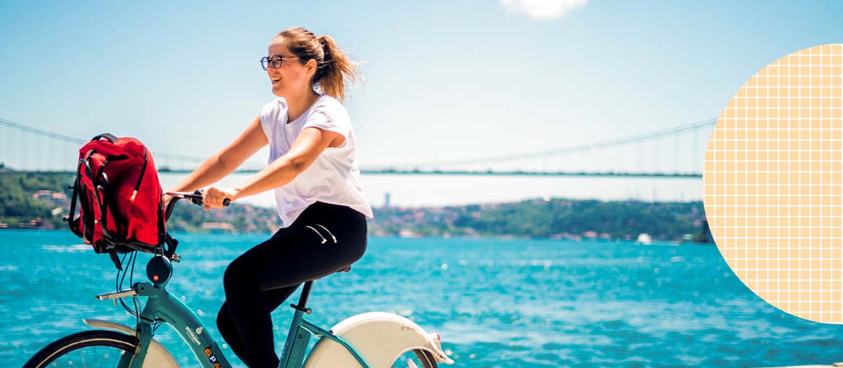 Woman riding her bike near a large body of water