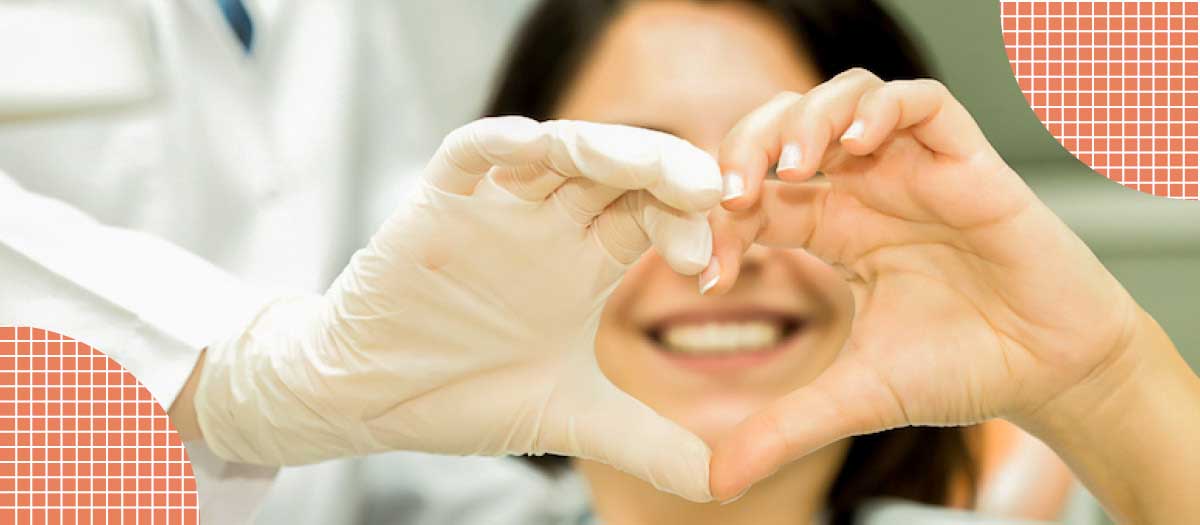 Woman making heart with hands over teeth