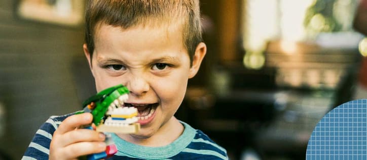 Kid holding up building blog teeth