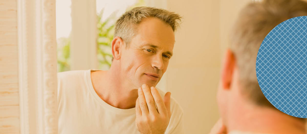 man looking at this mouth in the mirror