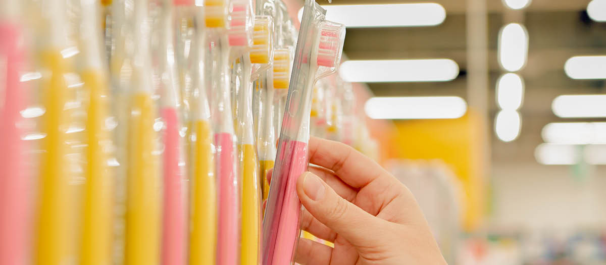 Person choosing a toothbrush off the shelf