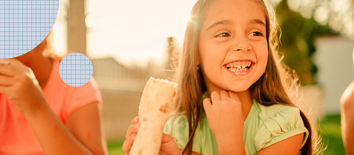 Young girl biting into a burrito