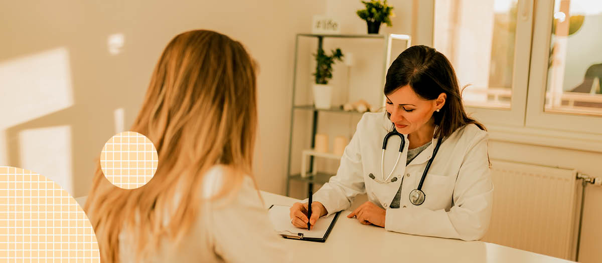 Doctor writing notes while talking to female patient