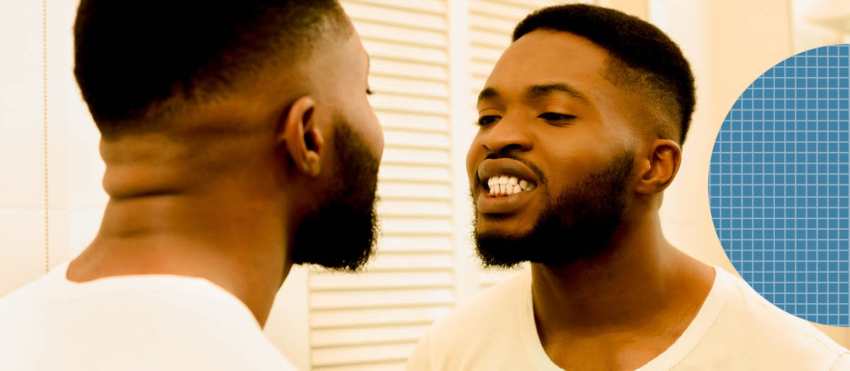 Man looking at teeth in mirror