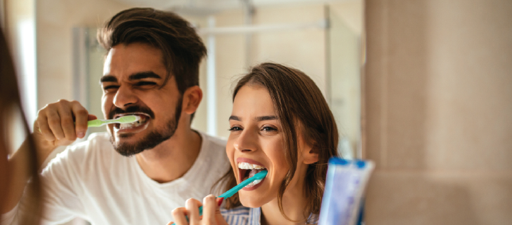 Couple brushing teeth in the mirror