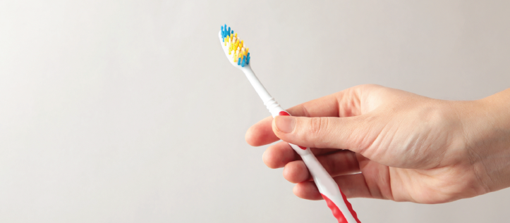 Hand holding up a tooth brush