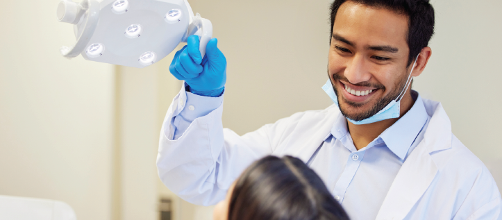 Male dentist smiling down at his patient