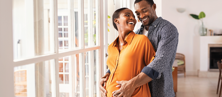 Young couple smiling while pregnant