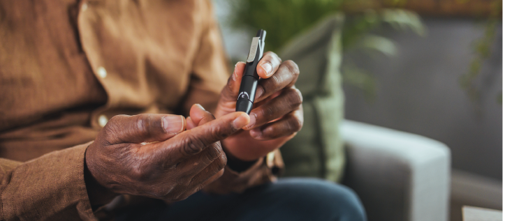 Diabetic man using a blood glucose monitor