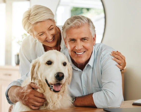 Senior couple with their dog smiling