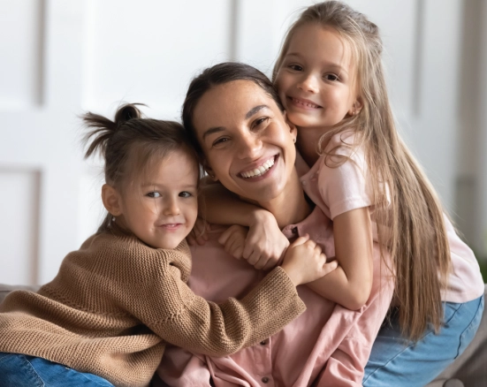 A mother with two young kids smiling about family dental insurance