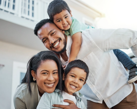 A family smiling outside their home