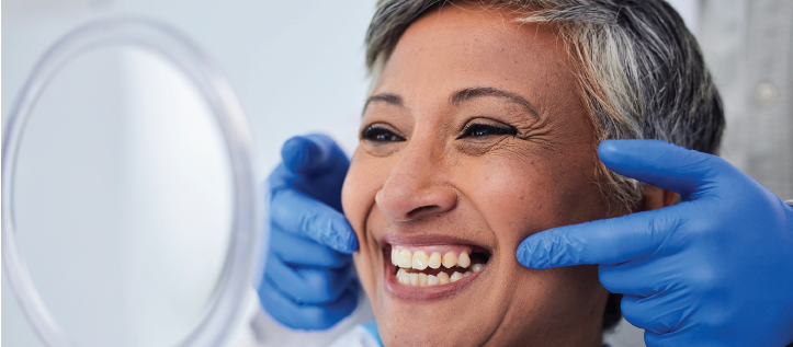 Middle age woman smiling after getting a gum graft surgery