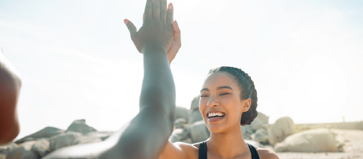 Active friends high fiving on the beach