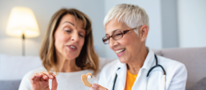 A doctor explaining a hearing aid to her patient