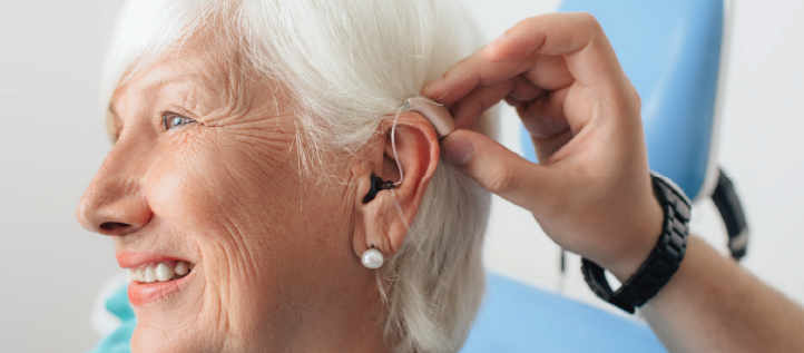 Senior woman getting wearing a hearing aid at an appointment