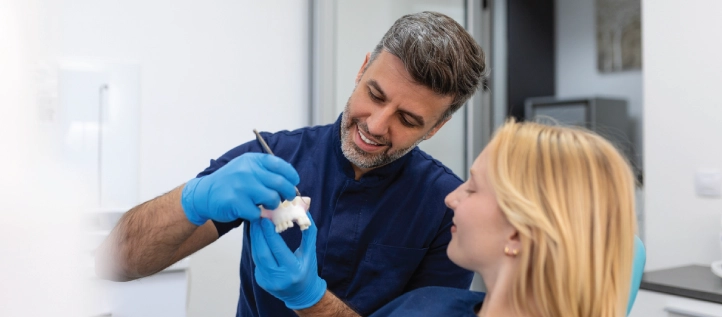 Dentist showing his patient what to expect when getting a dental bridge