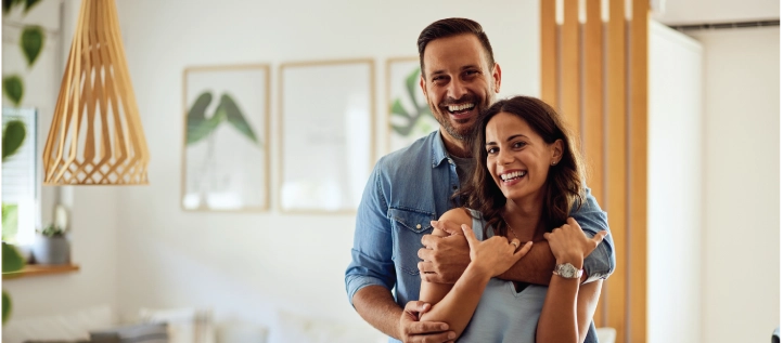 Young couple smiling and hugging in their home