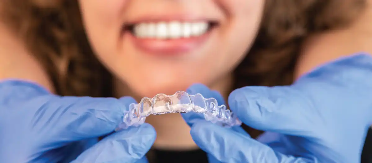 Young woman smiling before placing Invisalign on her teeth