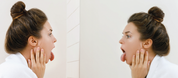 A young woman sticking out her tongue looking in the mirror