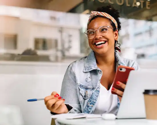 A young female student smiling while shopping for dental insurance in a coffee shop