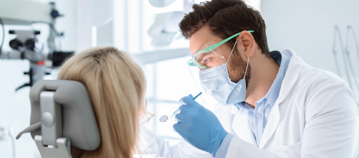 A dentist working on whitening a patients teeth