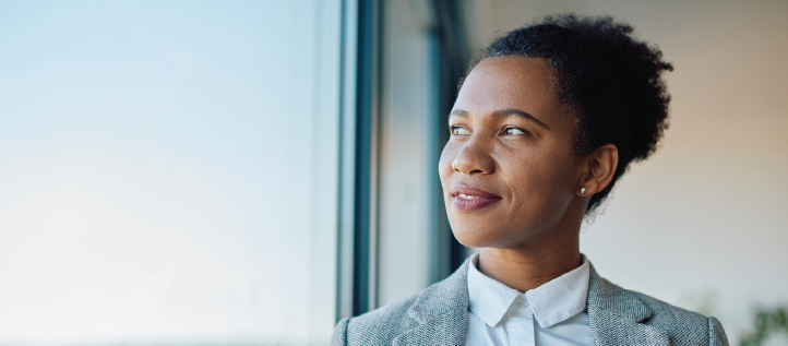 Business woman holding coffee and looking out the window