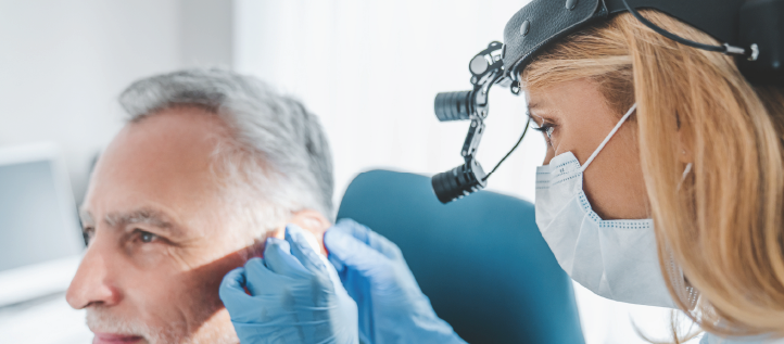 An older man getting his ear checked for Tinnitus